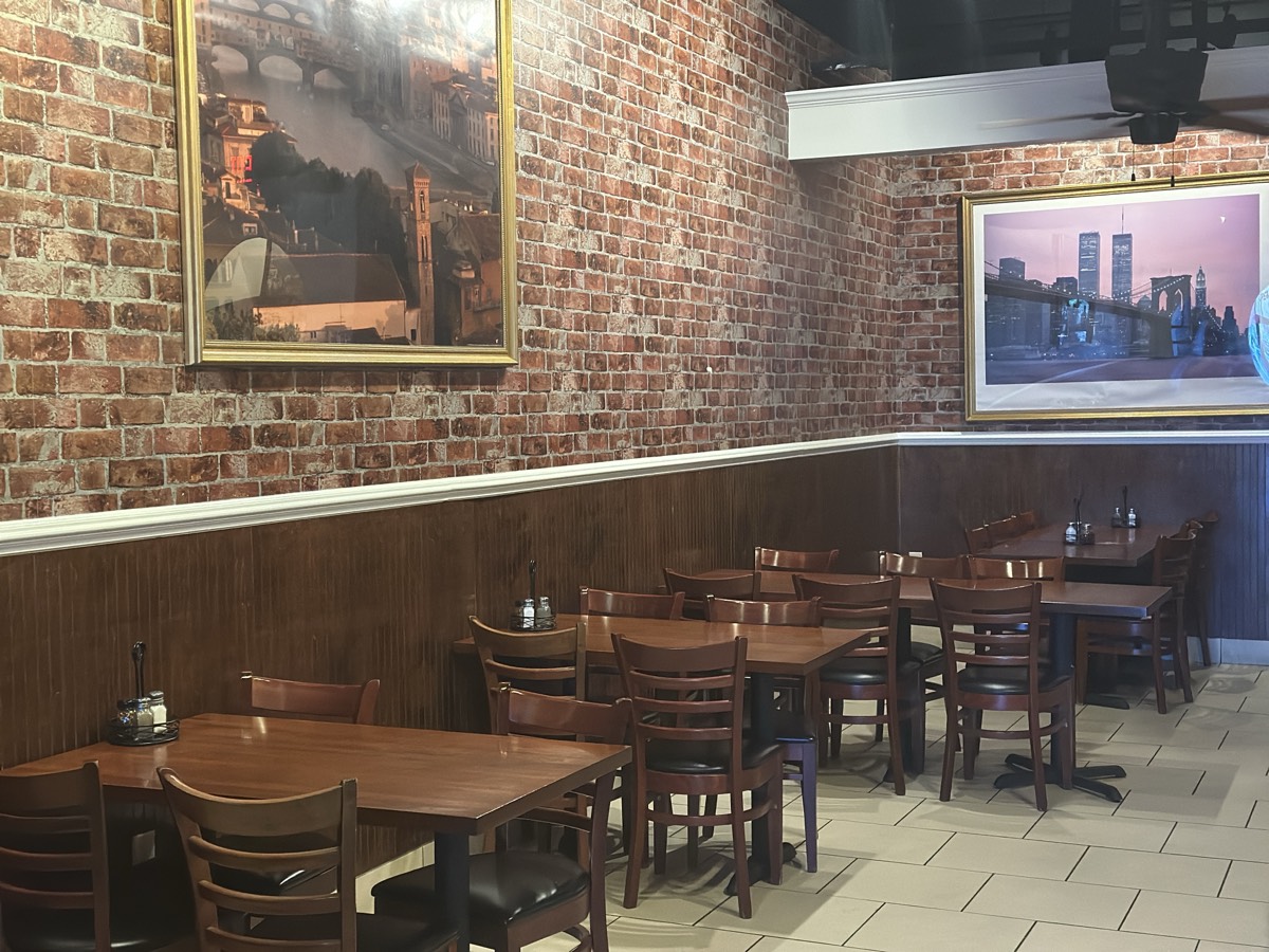 Capriccio restaurant dining space with rustic brick and warm Italian ambiance